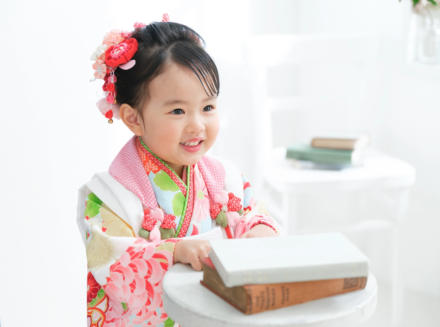 ピンクの着物で本を持つ女の子の七五三写真